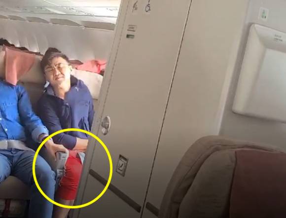 이른바 '빨간바지 아저씨'로 알려진 이윤준씨가 26일 비행 중 출입문이 열린 아시아나 항공기에서 근심스러운 표정을 짓고 있다. [사진=온라인 커뮤니티]