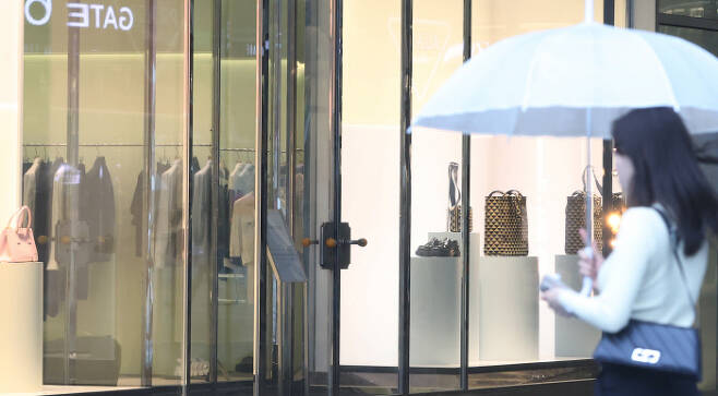 “갖고 싶다” 한 시민이 28일 핸드백과 구두 등 고가 제품이 전시돼 있는 서울지역 명품 브랜드 판매장을 바라보고 있다. 연합뉴스