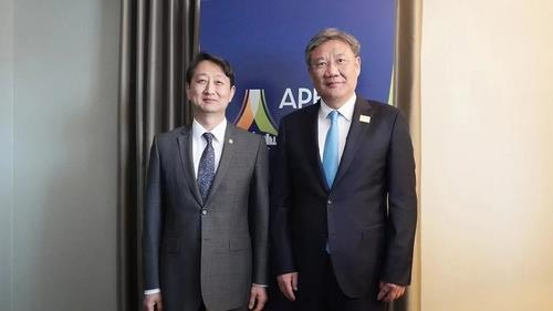 Korean Trade Minister Ahn Duk-geun, left, and Chinese Commerce Minister Wang Wentao take a photo on the sidelines of the Asia-Pacific Economic Cooperation conference in Detroit. [YONHAP]