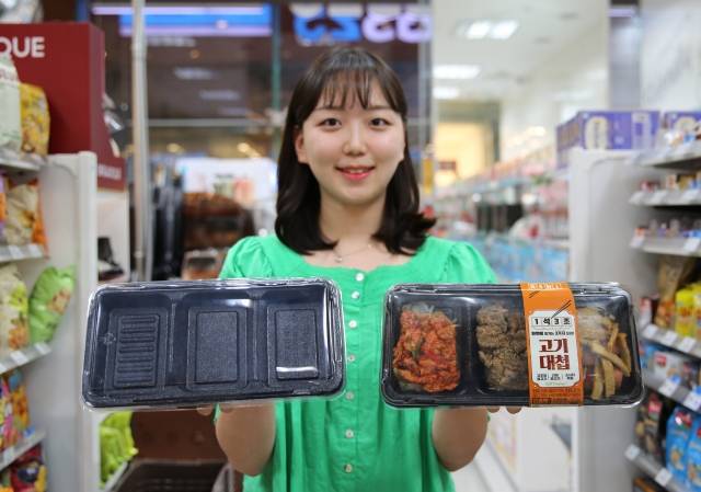 모델이 서울의 한 GS25 편의점에서 탄소 배출량 25%를 절감한 발포용기와 해당 용기를 사용한 간편식을 들고 포즈를 취하고 있다. GS25 제공