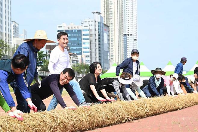 27일 울산 태화강 체육공원에서 김영길 울산 중구청장과 태화강마두희축제추진위원회 관계자, 마두희보존회 회원, 지역주민 등이 태화강마두희축제 마두희 큰줄당기기에 쓰일 마두희 본 줄(몸통 줄) 제작 행사에 참여하고 있다. [사진=울산 중구]
