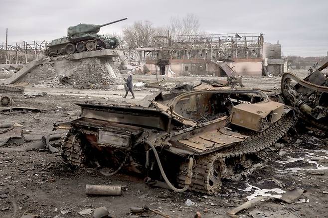 지난 2022년 3월 28일(현지시간) 우크라이나 트로스얀네츠 마을에서 한 주민이 파괴된 러시아군 전차 옆을 지나가고 있다. 우크라이나는 러시아군에 점령됐던 트로스얀네츠를 이틀 전 탈환했다. 사진=AP·뉴시스