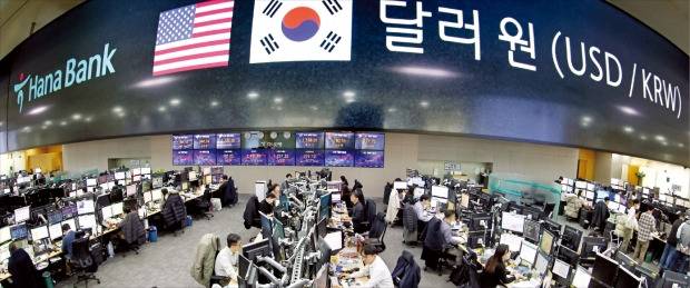 정부가 내년 7월부터 해외 은행과 증권회사의 국내 외환시장 직접 참여를 허용하는 등의 내용을 담은 ‘외환시장 선진화 방안’을 7일 발표했다. 70여 년 만의 대폭적인 외환시장 개방이다. 이날 서울 명동 하나은행 딜링룸에서 직원들이 외환 업무를 보고 있다.   /허문찬 기자