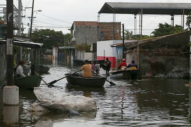 슈퍼 엘니뇨가 닥쳤던 2015~2016년 지구 곳곳에서는 여러 기상이변들이 있었다. 2015년 12월 홍수로 물에 잠긴 파라과이 아순시온의 거리를 주민들이 나룻배를 타고 이동하고 있다(위).  AFP=연합뉴스