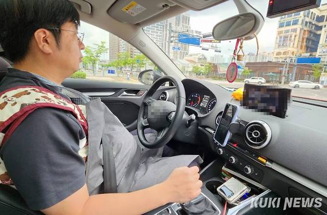체험복을 입고 운전대를 잡은 기자.&nbsp;