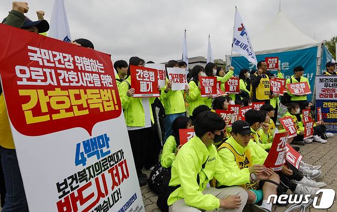 보건복지의료연대 회원들이 18일 서울 영등포구 국회 앞에서 열린 간호법 제정 반대 집회에서 '간호법 폐기'가 적힌 피켓을 들어 보이고 있다. 2023.4.18/뉴스1 ⓒ News1 김도우 기자