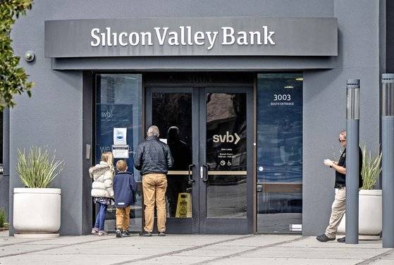 미국 캘리포니아 실리콘 밸리 은행(SVB)이 3월10일 파산했다. 사진은 하루 뒤인 11일 미국인들이 길을 가다 은행 로비문에 게시된 메시지를 읽고 있다. [UPI=연합뉴스]