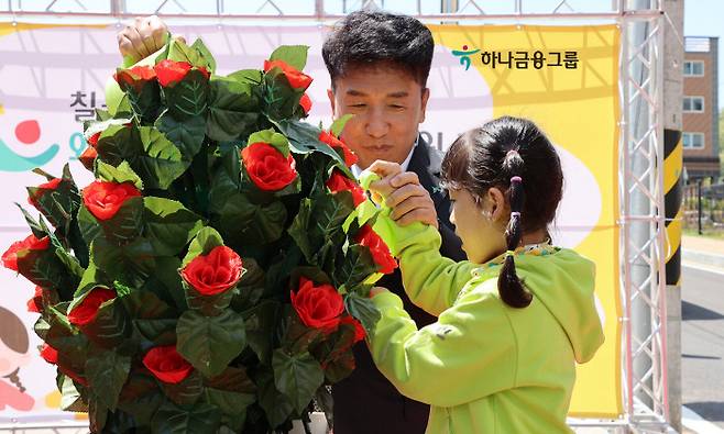 함영주 하나금융그룹 회장이 지난 4월 말 문을 연 국공립 칠곡 왜관하나어린이집에서 한 어린이와 개원 축하 화분을 손질하고 있다.