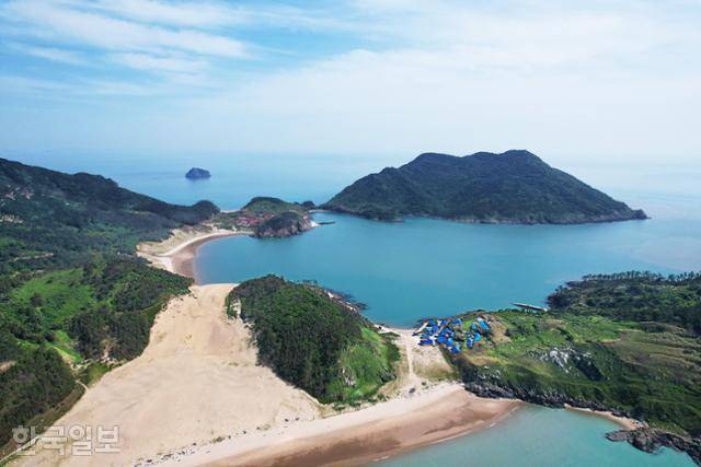신안 우이도는 '자산어보'의 저자 정약전이 유배당한 섬이다. 섬 서쪽 끝 바람이 만든 모래언덕(풍성사구)에서 한적한 해변이 이어진다. 성촌마을(파란 지붕)과 돈목마을이 해변 양쪽에 자리 잡고 있다.