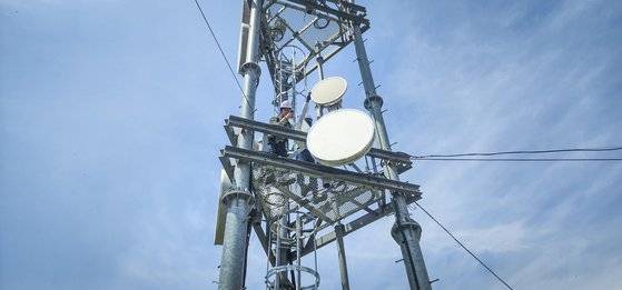 SKT 직원들이 도서 지역에 설치된 5G 마이크로웨이브 통신 장비를 점검하는 모습. 사진 SK텔레콤