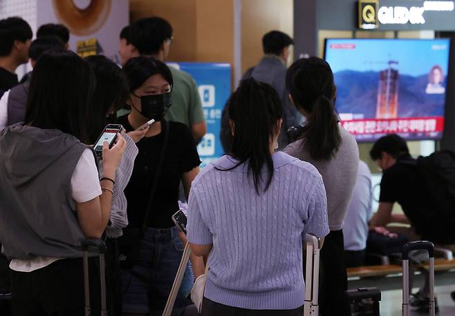 북한이 31일 오전 6시29분께 평안북도 동창리 일대에서 남쪽 방향으로 북한이 주장하는 우주발사체를 발사했다고 합동참모본부가 밝혔다. 이날 오전 서울역 대합실 TV에 관련 뉴스속보가 나오는 가운데 수학여행을 떠나기 위해 모인 학생들이 갑작스럽게 울린 경보음을 듣고 휴대전화 안전안내문자를 확인하고 있다. [사진=연합뉴스]