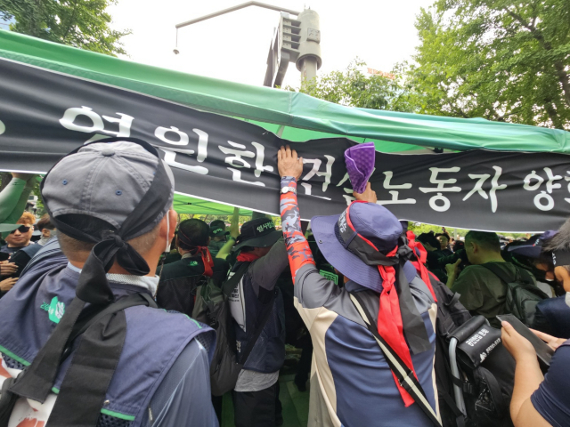 31일 민주노총 건설노조 조합원들이 서울 중구 파이낸스센터 건물 앞에 기습설치한 고(故) 양회동씨의 분향소 해산을 막고 서 있다. 정유민 기자
