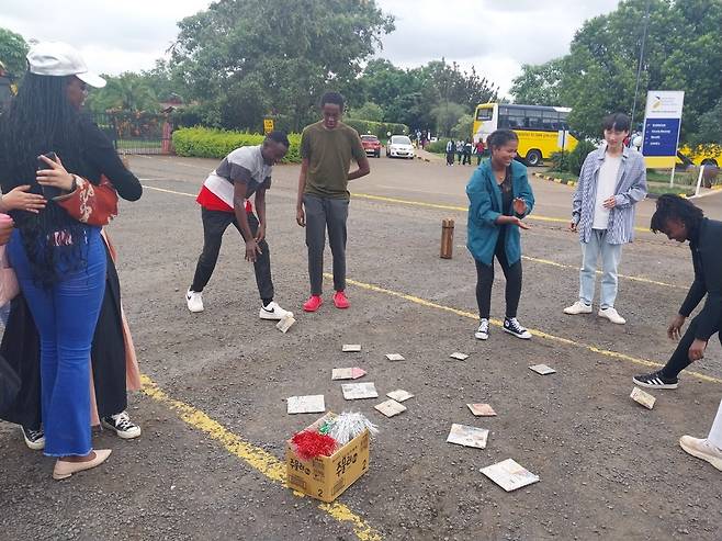 케냐서 우리 음식·문화 알리는 한국 대학생들 (나이로비=연합뉴스) 우만권 통신원 = 지난 30일(현지시간) 케냐 수도 나이로비에 있는 미국국제대학교(USIU) 케냐 분교에 재학 중인 한국 학생들이 우리 음식·문화를 알리기 위해 마련한 행사장에서 현지 학생들이 우리 전통 놀이인 딱지치기를 배우고 있다. 2023.5.31 airtech-kenya@yna.co.kr