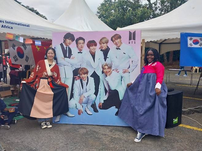 케냐서 우리 음식·문화 알리는 대학생들 (나이로비=연합뉴스) 우만권 통신원 = 지난 30일(현지시간) 케냐 수도 나이로비에 있는 미국국제대학교(USIU) 케냐 분교에 재학 중인 한국 학생들이 우리 음식·문화를 알리기 위해 마련한 행사장에서 한국과 케냐의 여학생이 방탄소년단(BTS) 사진 앞에서 포즈를 취하고 있다. 2023.5.31 airtech-kenya@yna.co.kr
