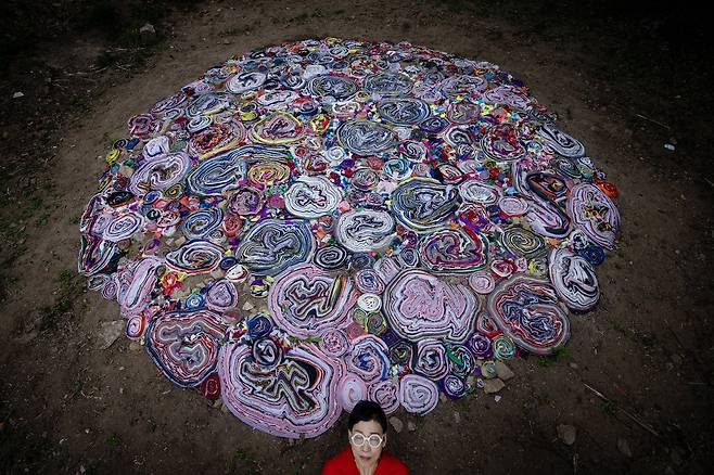 지나 손은 자하미술관 숲에 자투리 천을 세로로 세워 심었다. 이름하여 ‘여름의 색’이다. 대지에 촘촘히 심은 헝겊의 겹엔 그의 정체성이 깃들어 있다. 지난해 5월 유방암 판정을 받은 그는 대지에 핀 색 덩어리에 자신의 몸속에 핀 몹쓸 꽃을 투영한 게다. 결국 그가 호미로 이 가상의 꽃, 가상의 색을 심은 뜻은 그가 다시 일어서서 찬란하게 피어날 시간을 모두와 나누고 싶었던 게다.