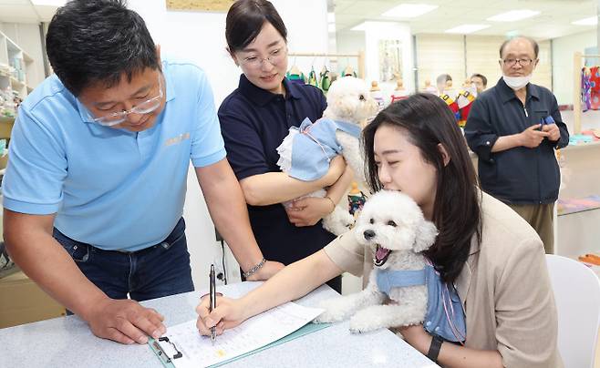 서울 강서구 김포공항 국내선 청사에서 1일 오후 문을 연 ‘공항 애견센터’에서 첫 이용객이 여행에 앞서 반려견 위탁 서비스를 신청하고 있다. 연합뉴스