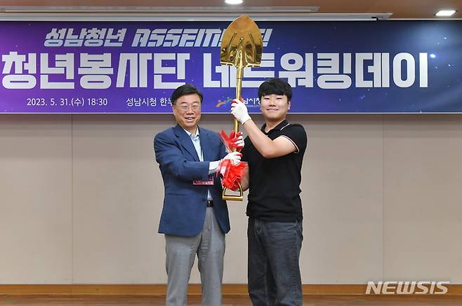 [성남=뉴시스] 신상진 성남시장이 청년봉사단의 상징물인 황금삽을 전달하고 있다.