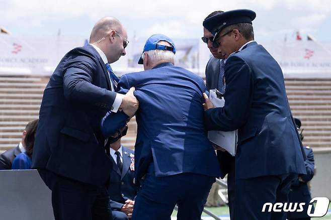 조 바이든 미국 대통령이 1일(현지시간) 콜로라도주에 있는 공군사관학교 졸업식에서 연설을 하다 넘어져서 부축을 받고 있다. ⓒ AFP=뉴스1 ⓒ News1 이유진 기자