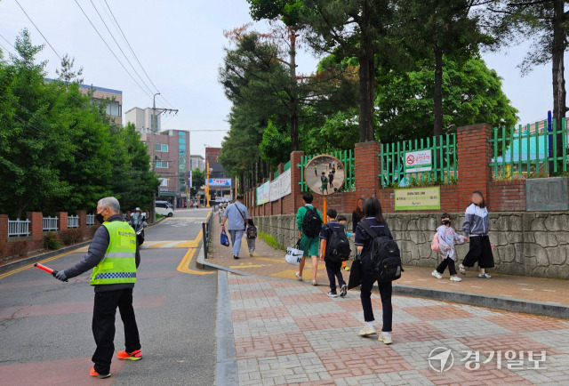 수원특례시의 한 초등학교 앞에서 학교안전지킴이가 등교 지도를 하는 모습. 오민주기자