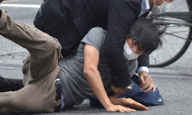 지난 2022년 7월 8일 일본 나라현 나라시 야마토사이다이지역 앞에서 참의원 선거 유세활동을 하던 아베 신조 전 일본 총리(67)를 총기로 저격한 용의자 야마가미 데쓰야(아래·41)가 범행 직후 제압당하고 있다. 교도연합뉴스