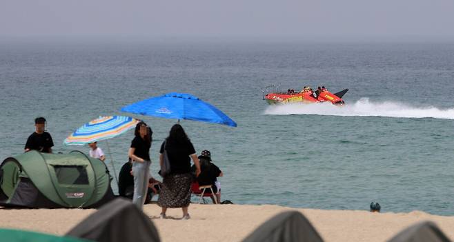 초여름 무더위가 6일까지 이어지는 징검다리 연휴에 계속될 것으로 보인다. 지난달 21일 강원 강릉시 경포해수욕장을 찾은 관광객들이 무더위를 식히고 있다. 연합뉴스