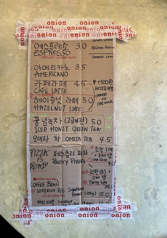카페 ‘어니언 광장시장’ 메뉴판. 시장 상인들처럼 박스 뒷면에 검은 매직으로 글씨를 쓰고 테이프로 대충 붙인 분위기가 흥미롭다. 최기웅 기자