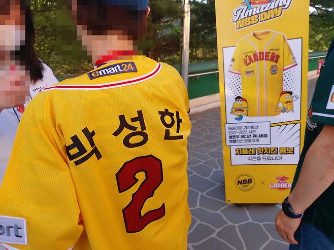 2일 인천 미추홀구 SSG랜더스필스 1루 매표소 앞에서 2022~2023 시즌 옐로우 에디션 유니폼을 착용하고 입장하는 야구 팬에게 NBB 치폴레 핫 치킨 콤보 무료 교환권을 증정하는 모습. 김희량 기자