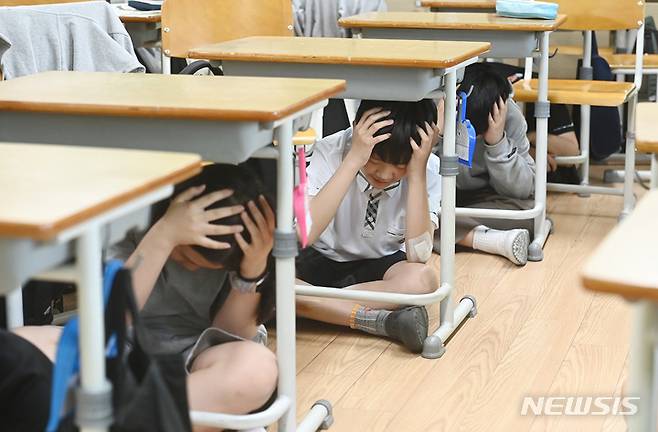 [수원=뉴시스] 김종택 기자 = 강원도 동해시 북동쪽 59km 해역에서 규모 4.5의 지진이 발생한 지난달 15일 경기도 수원시 권선구 칠보중학교에서 학생들이 지진 대피 교육을 받고 있다. 이날 정부는 지진 위기 경보를 관심에서 주의 단계로 상향 조정했다. 2023.05.15. jtk@newsis.com