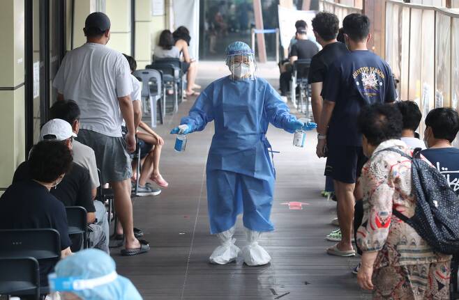 지난 해 8월 서울 송파구보건소에 마련된 코로나19 선별진료소에서 의료진이 소독제를 뿌리고 있는 모습./뉴스1