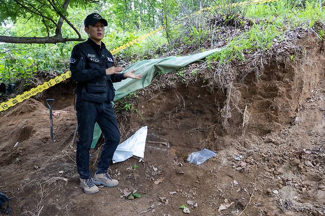 국방부 유해발굴감식단 발굴팀장 남궁탄 상사가 734고지에서 발견된 전사자 유해 옆에서 이후 이뤄질 정밀발굴을 설명하고 있다.