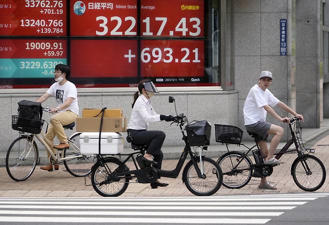 5일 일본 도쿄 시내의 주식 현황판 앞을 시민이 지나가고 있다. 이날 닛케이225지수는 3만2120.56으로 마감했다. EPA연합뉴스