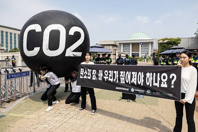 청년환경단체 회원들이 대형 탄소를 짊어지며 국회의 기후위기 대응을 촉구하고 있다. [그린피스]