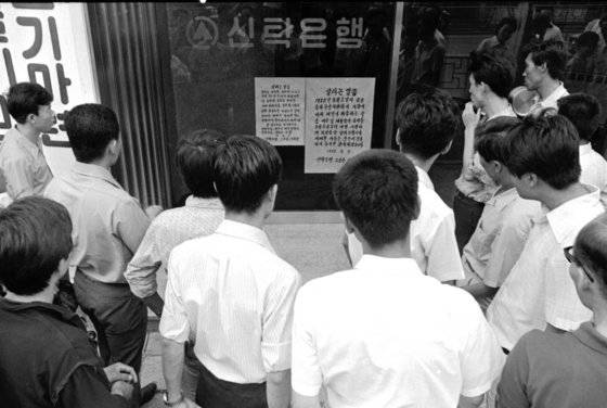 1972년 8월 3일 기업 사채에 관한 경제안정과 성장에 관한 긴급명령 15호, 이른바 사채 동결 조치가 발동했다. 사채 시장을 제도권 금융으로 흡수한 조치다. 은행에 붙은 관련 안내문을 시민들이 읽고 있다. [중앙포토]
