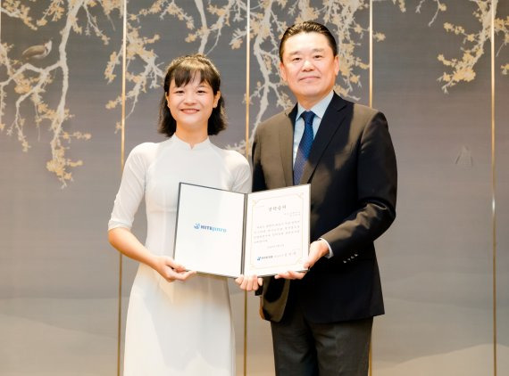 지난 5일 하노이에서 김인규 하이트진로 대표(오른쪽)가 베트남 대학생에게 장학금을 전달하고 있다.