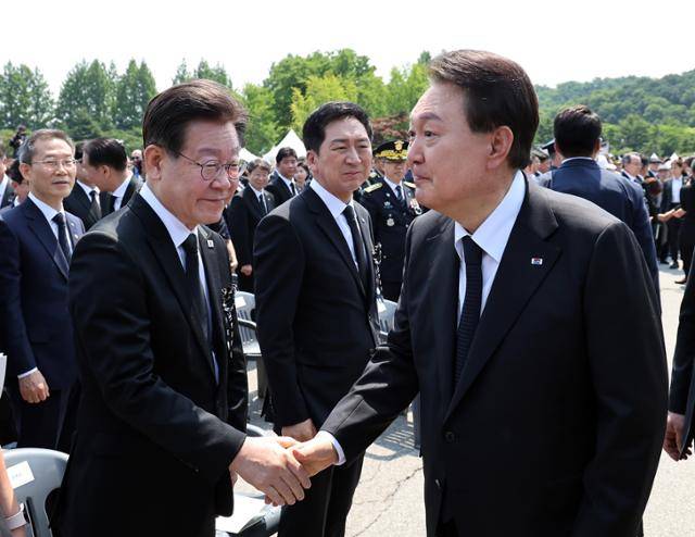 윤석열(오른쪽) 대통령이 6일 서울 동작구 국립서울현충원에서 열린 제68회 현충일 추념식을 마친 뒤 이재명 더불어민주당 대표와 악수하고 있다. 대통령실통신사진기자단