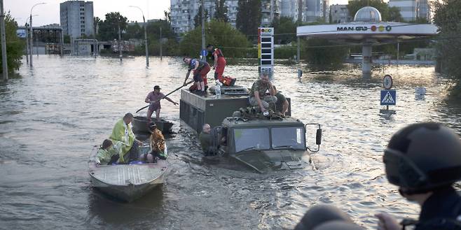대피하는 주민들 우크라이나 남부 헤르손주에 있는 카호우카댐이 6일 오전(현지시간) 붕괴해 하류에 있는 헤르손 시가지가 물에 잠기자 주민들이 배를 타고 대피하고 있다. AP연합뉴스