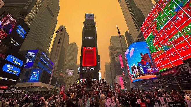 2023년 6월 7일(현지시간) 미국 뉴욕 맨해튼이 캐나다에서 발생한 산불로 남하한 연기와 안개로 뒤덮인 가운데 타임스퀘어에 사람들이 몰려 있다. /로이터 연합뉴스