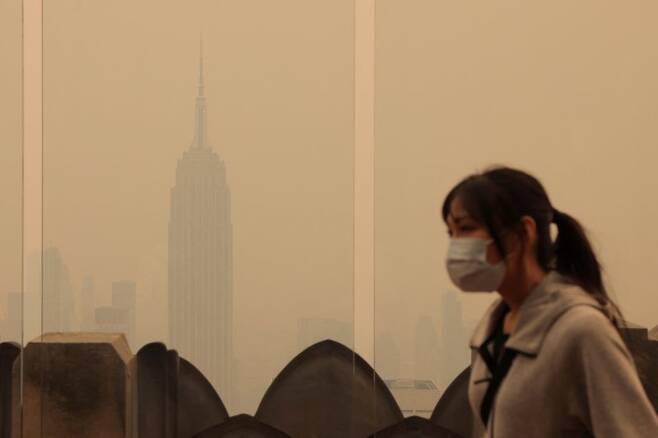 뉴욕 시민이 7일(현지시간) 마스크를 착용하고 잿빛으로 뒤덮인 뉴욕 시내를 걸어가고 있다. /사진=로이터연합뉴스