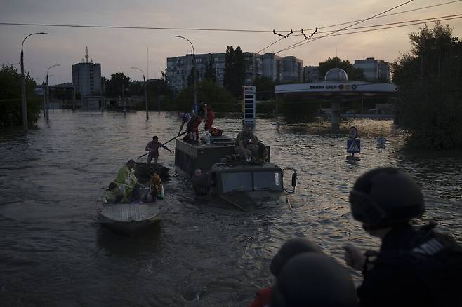 6일(현지시각) 우크라이나 남부 노바 카호우카댐이 붕괴되면서 홍수가 발생한 헤르손에서 주민들이 대피하고 있다. AP 연합뉴스