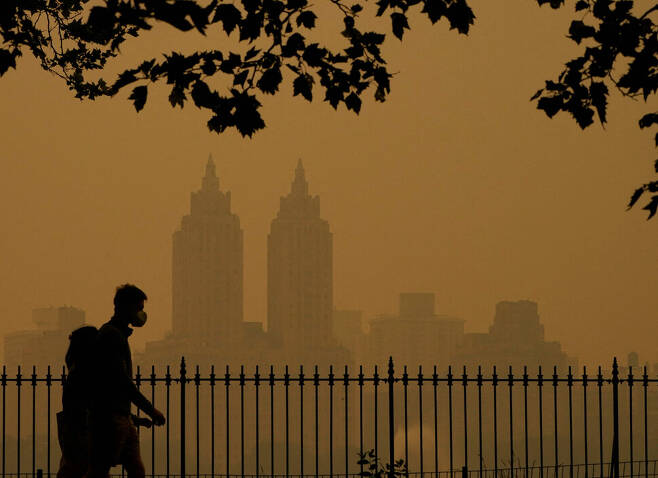 캐나다에서 발생한 산불로 인한 연기가 뉴욕시를 뿌옇게 뒤덮은 가운데 7일(현지시각) 사람들이 센트럴 파크에서 산책하고 있다. AFP 연합뉴스