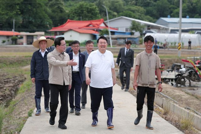 윤석열 대통령이 7일 충남 부여군 임천면의 '꿈에영농조합법인' 모내기 현장을 방문해 정황근 농림축산식품부 장관(왼쪽), 농민들과 대화하고 있다. 대통령실 제공