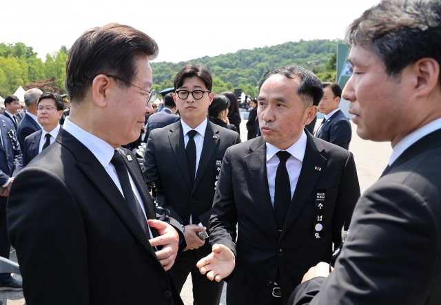 더불어민주당 이재명 대표(왼쪽)가 6일 서울 동작구 국립서울현충원에서 열린 제68회 현충일 추념식장에서 추념식이 끝난 뒤 최원일 전 천안함장(가운데)으로부터 항의를 받고 있다. 연합뉴스