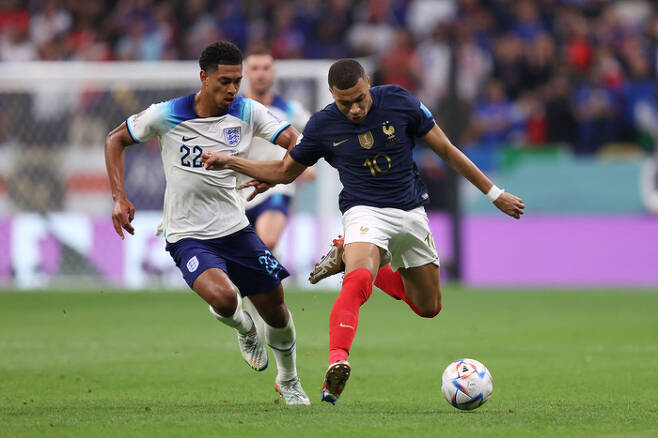 카타르 월드컵 8강에서 프랑스의 킬리안 음바페와 볼 다툼을 벌이는 주드 벨링엄. 게티이미지코리아