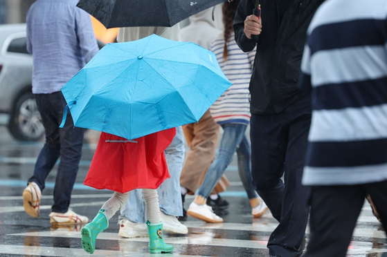 비가 내린 날 서울 광화문네거리에서 사람들이 우산을 쓰고 횡단보도를 건너는 모습. 〈사진=연합뉴스〉