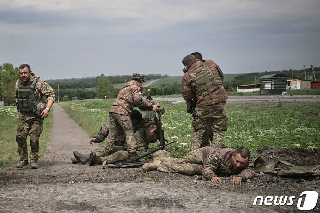 2022년 5월 21일(현지시간) 러시아의 침공 속 우크라이나 돈바스 인근에서 탱크 부대원들이 동료를 도와 주고 있다. ⓒ AFP=뉴스1 ⓒ News1 우동명 기자