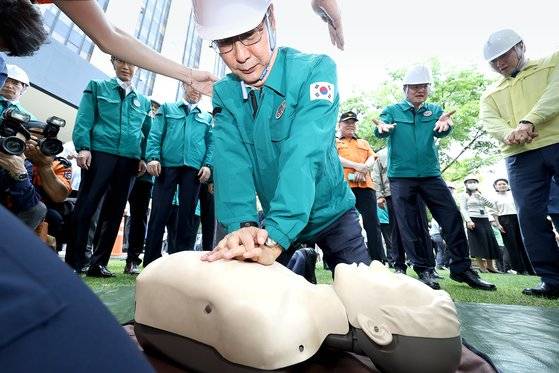 한덕수 국무총리가 지난 5월 16일 정부서울청사에서 열린 제414차 민방위날 훈련에 참여해 심폐소생술 체험을 하고 있다. 당초 전 국민 대상 훈련으로 계획했으나 막판에 공공 부문으로 축소했다.[연합뉴스]