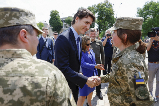 트뤼도 캐나다 총리가 우크라이나 키이우의 추모의 벽에서 우크라이나 병사를 만나 인사를 나누고 있다. AP 연합뉴스