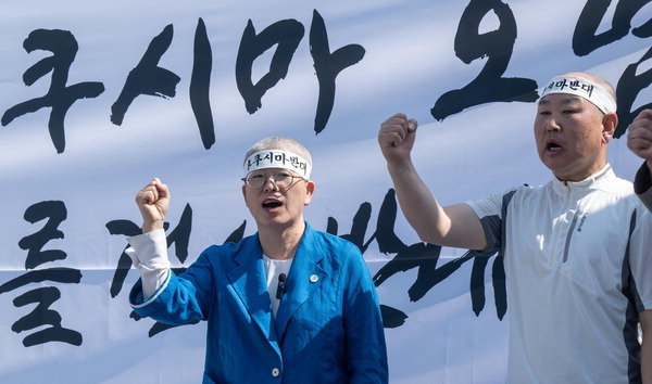 지난달 17일 금정구 부산대학교 정문 앞에서 김경지 민주당 금정지역위원장(왼쪽부터)과 유정호 당원이  '후쿠시마 오염수 방류 반대 결의대회'에서 삭발식 후 구호를 외치고 있다. 이원준 기자