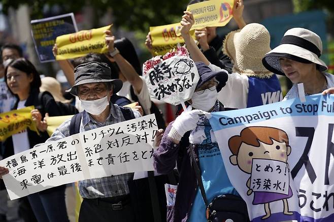 [도쿄=AP/뉴시스] 5월 16일 일본 도쿄에 있는 도쿄전력(TEPCO) 본사 앞에서  시위대가 '오염수 방류 반대' 현수막을 들고 후쿠시마 오염수 방류에 반대하고 있다. 이날 수십 명의 반핵운동가가 쓰나미로 파괴된 후쿠시마 원자력 발전소를 운영하는 도쿄전력 밖에 모여 방사능 오염수 방류 계획 철회를 요구했다. 2023.05.16.