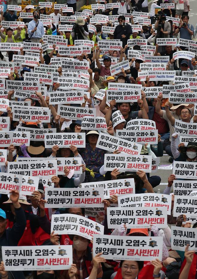 12일 오후 서울 여의도 국회 앞에서 ‘일본 방사성 오염수 해양투기 저지 2차 전국 행동의날 전국 어민대회’가 열렸다. 참가자들이 손팻말을 들고 있다. 김혜윤 기자